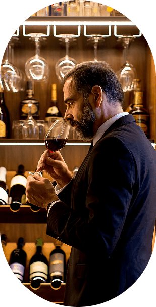 Wine Ambassador in elegant suit tasting red wine during exclusive wine tasting experience at ŒLYSIUM